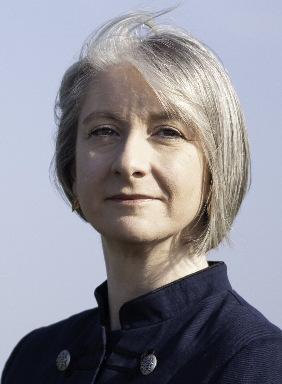 Cornelia Raubal in a navy jacket against a pale blue sky
